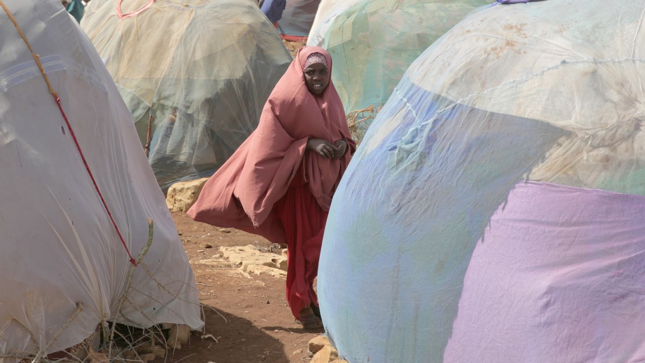 A young girl stands in front of makeshift shelters in Baidoa. More than 6 million people need food assistance in Somalia. 
