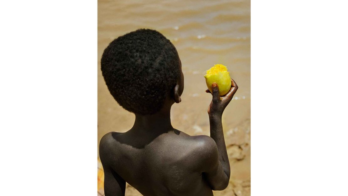 Boy with mango at Lake Bam, near the town of Kongoussi, Burkina Faso