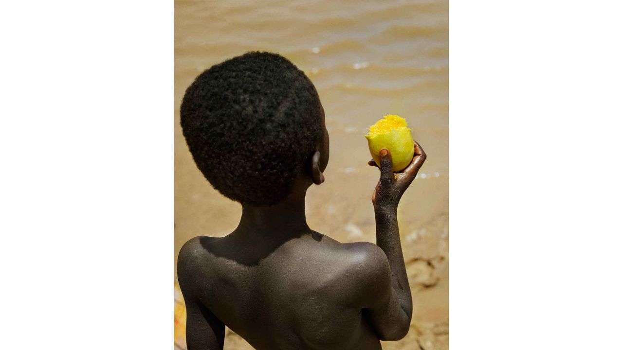Boy with mango at Lake Bam, near the town of Kongoussi, Burkina Faso
