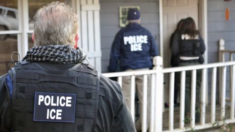 ICE agents stand outside an Atlanta home during a February operation.