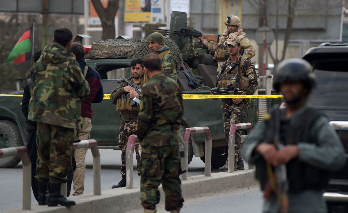 Afghan security personnel gather outside the hospital.