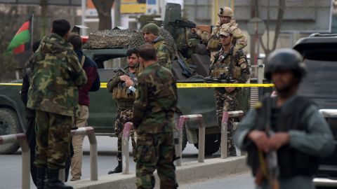 Afghan security personnel gather outside the hospital.