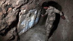 A member of the Iraqi troops examine ancient artifacts found in an underground ISIS tunnel in eastern Mosul. 