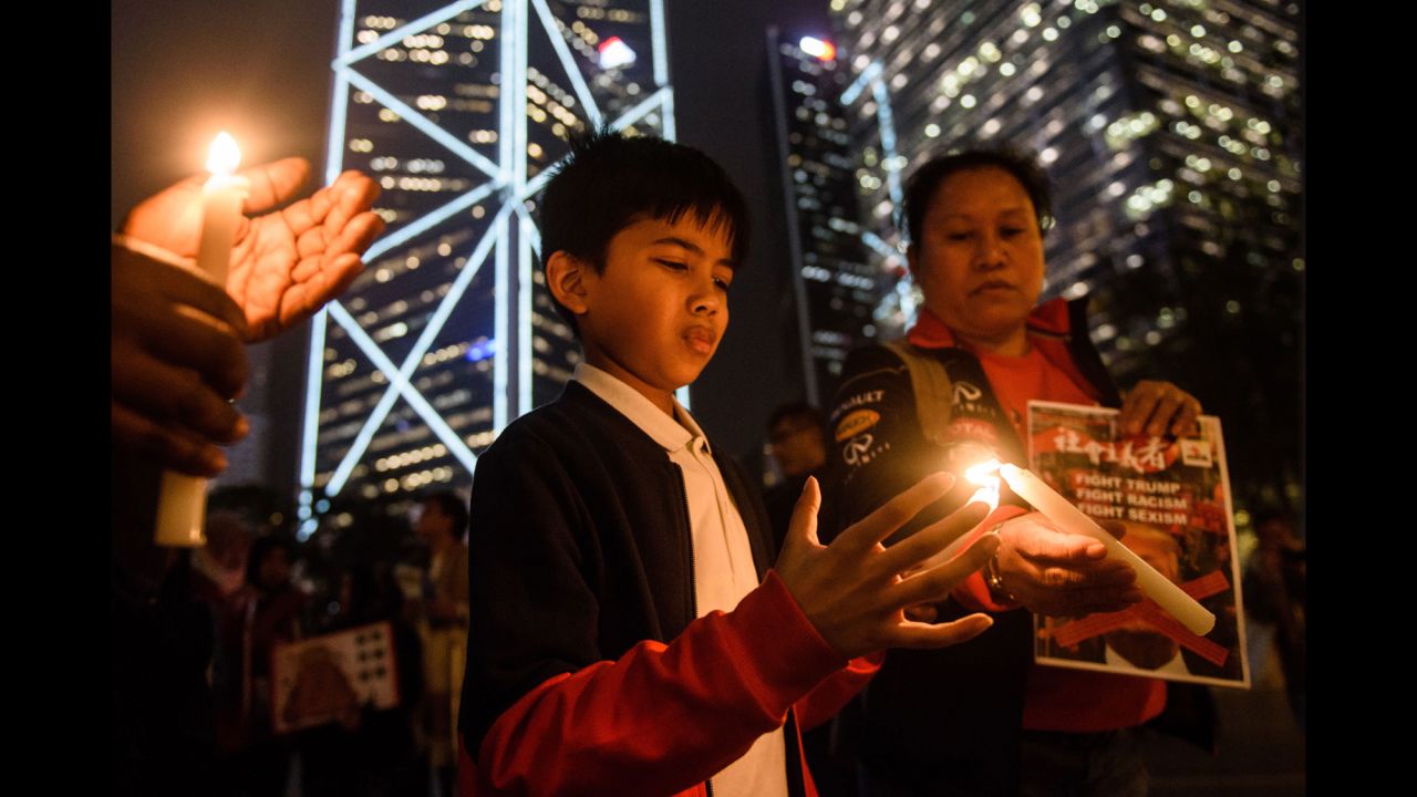A woman helps a boy light a candle in Hong Kong.