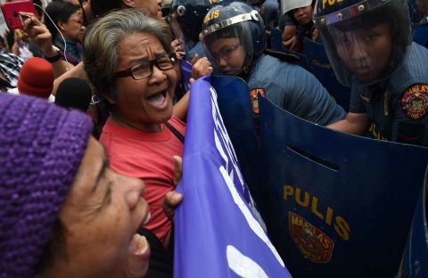 Members of a women's group face off against female police officers as they shout anti-American slogans near the US Embassy in Manila, Philippines. Many protesters this year have turned out to voice their disagreement with the policies and rhetoric of US President Donald Trump, especially regarding women's issues.