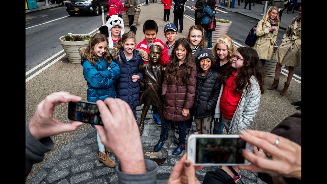 Children crowd around the "Fearless Girl" statue for a group photo. She <a href="http://money.cnn.com/2017/03/08/news/wall-street-fearless-girl-reaction/">has become the most popular girl on Wall Street</a>, and some fans are pushing for the statue to remain a permanent fixture.