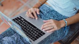 beautiful girl in a relaxed position working at a laptop in a cafe . Freelancing on vacation . Working in co-working in a cafe in the open air .