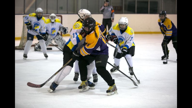 Canadian Kelly Whelan, who plays for Kyiv Ukrainochka, jostles for the puck with Dnipro Queens' Katerina Rudchenko during the finals.