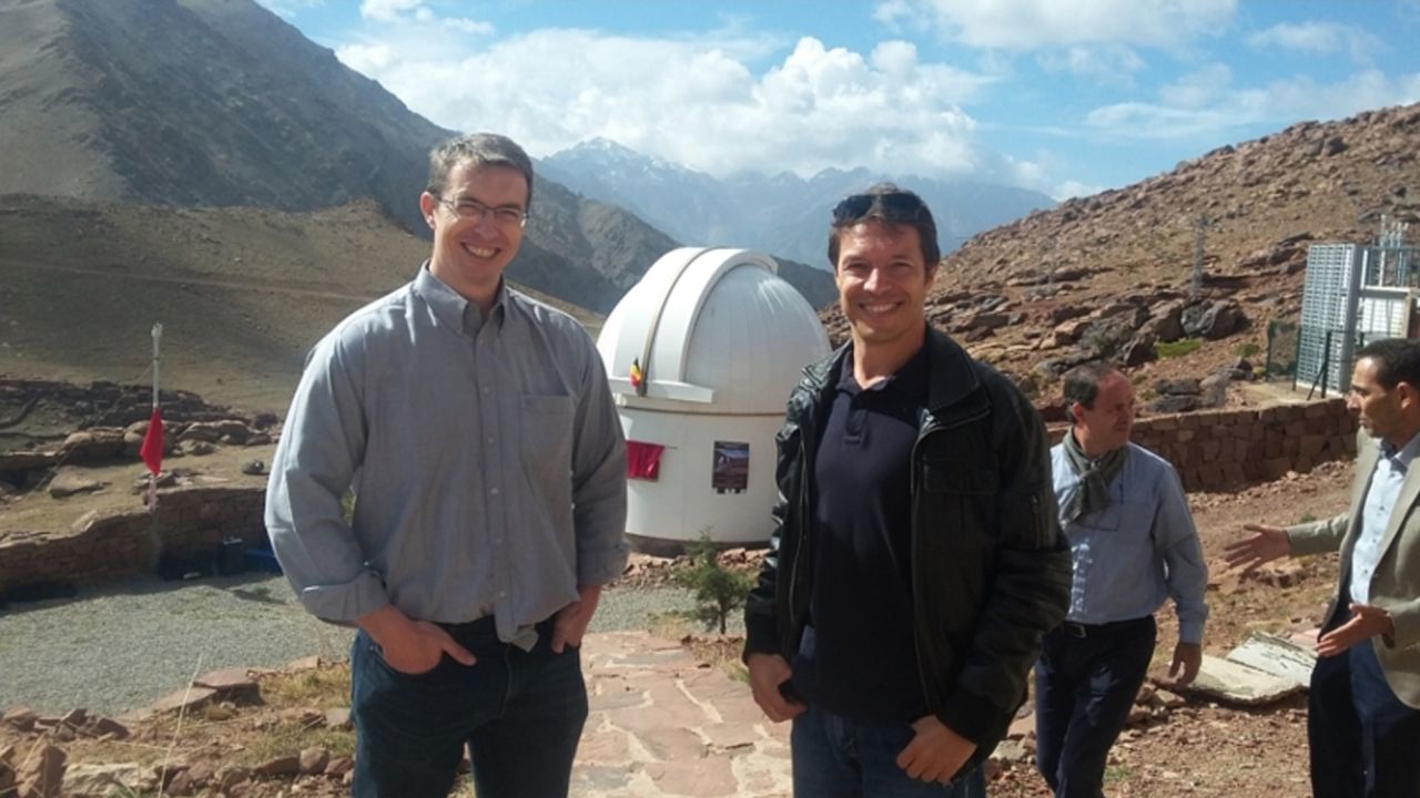 Gillon and Jehin pose with one of their telescopes.