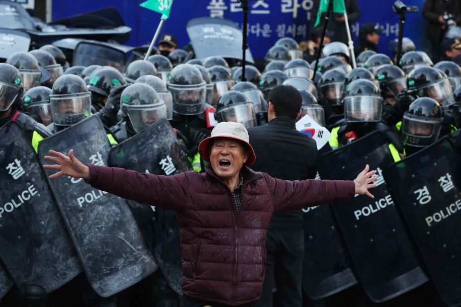 A Park supporter shouts slogans in front of a police line.