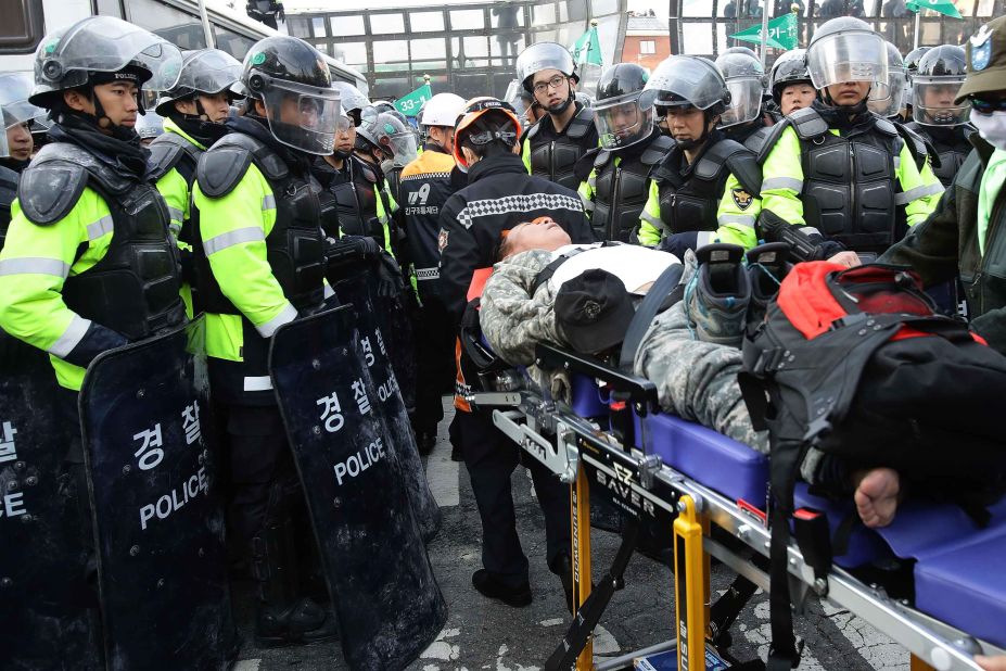 An injured Park supporter lies on a stretcher surrounded by police.