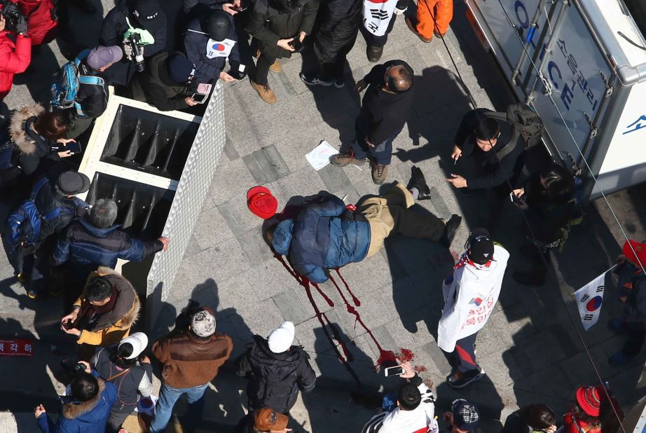 A supporter of the ousted president lies in a pool of blood as protesters push to pass a police barricade preventing them from reaching the Constitutional Court. According to police, two people died in the protests. A statement from acting President Hwang Kyo-ahn said several people also were injured.