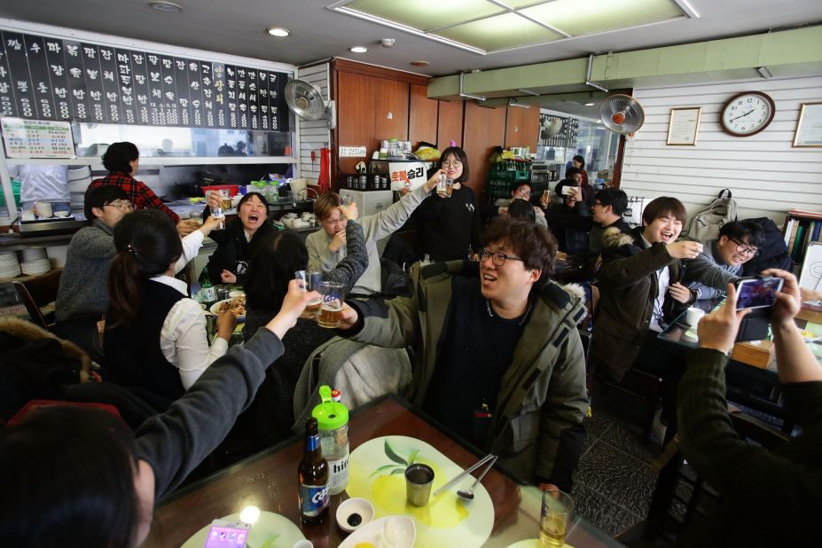 South Koreans celebrate at a restaurant after hearing the court's unanimous verdict.