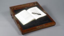 Portable writing desk that belonged to Jane Austen. Open book and spectacles.