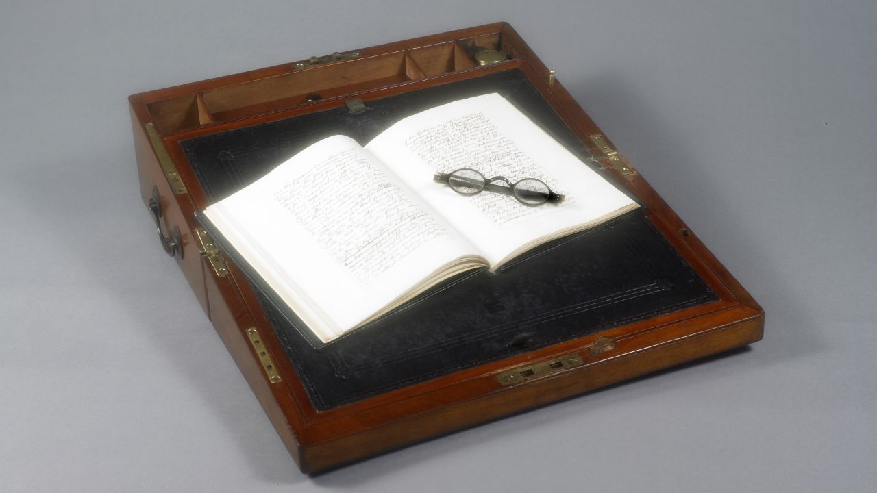 Portable writing desk that belonged to Jane Austen. Open book and spectacles.