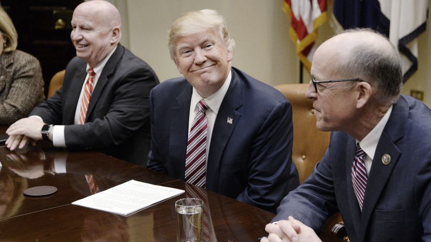 U.S. President Donald Trump, center, smiles as Representative Greg Walden, a Republican from Oregon, right, and Representative Kevin Brady, a Republican from Texas, sit during a discussion on health care in the Roosevelt Room of the White House in Washington, D.C. U.S., on Friday, March 10, 2017. 