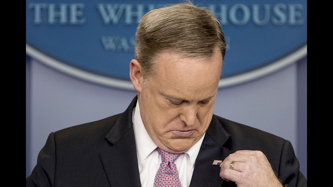 White House press secretary Sean Spicer adjusts his American flag pin after he was told that it was upside down on Friday, March 10.