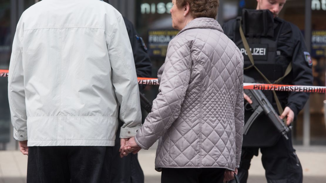 Two passers-by stand Saturday outside the Limbecker Mall in Essen, Germany. The mall was closed due to a terror threat.