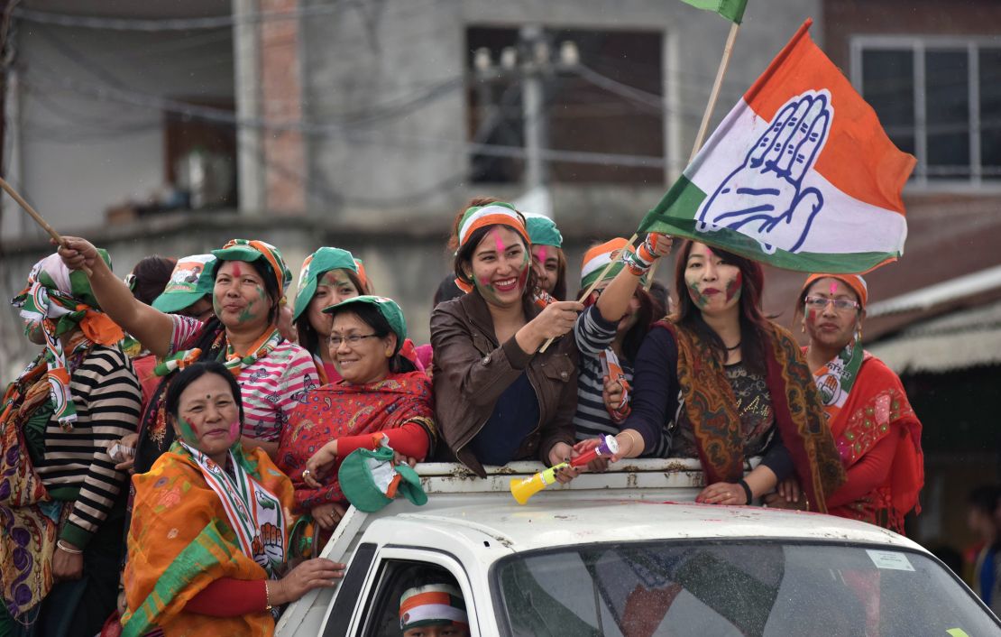 Supporters of India's Congress wave their flags as they celebrate their candidate's win in state assembly elections in Imphal on March 11.
