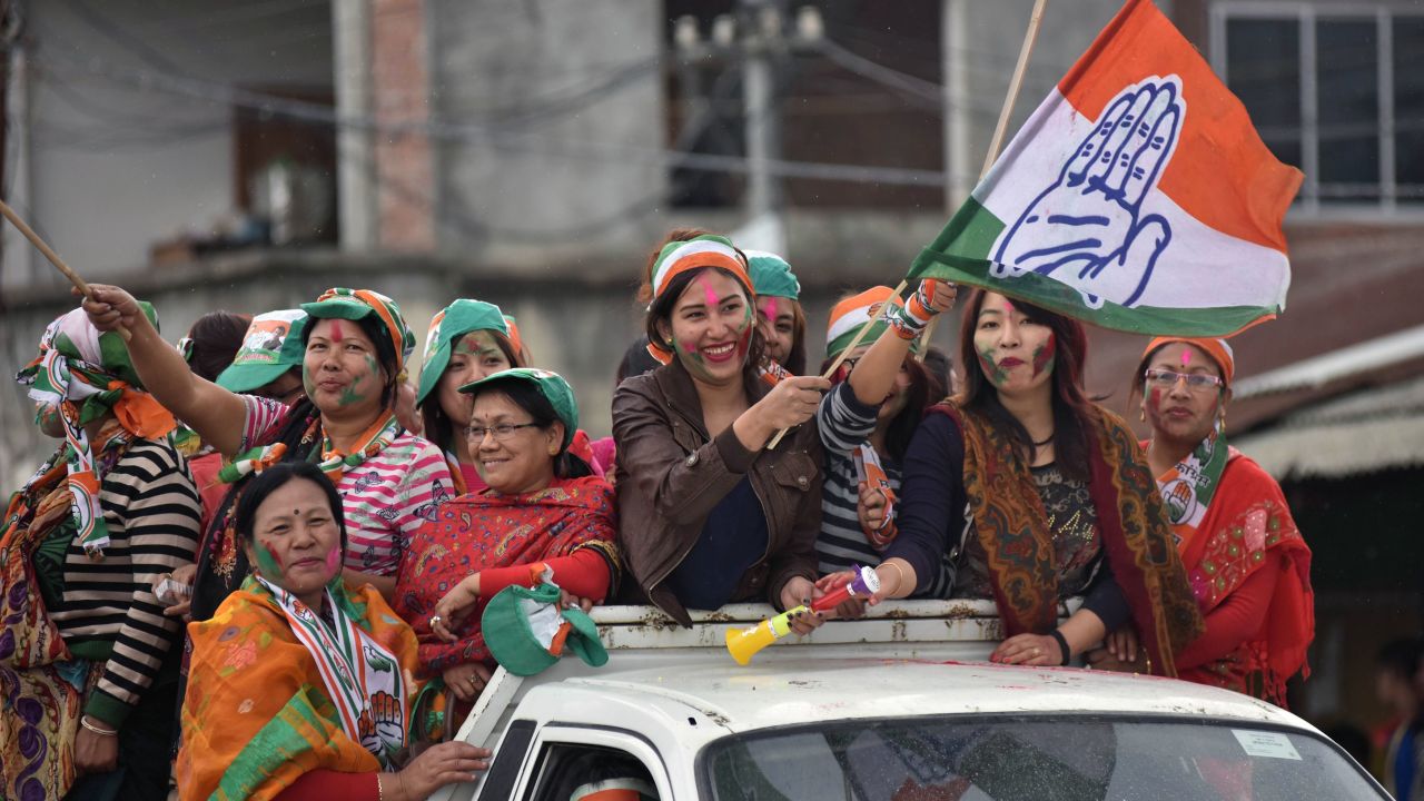 Supporters of India's Congress wave their flags as they celebrate their candidate's win in state assembly elections in Imphal on March 11.