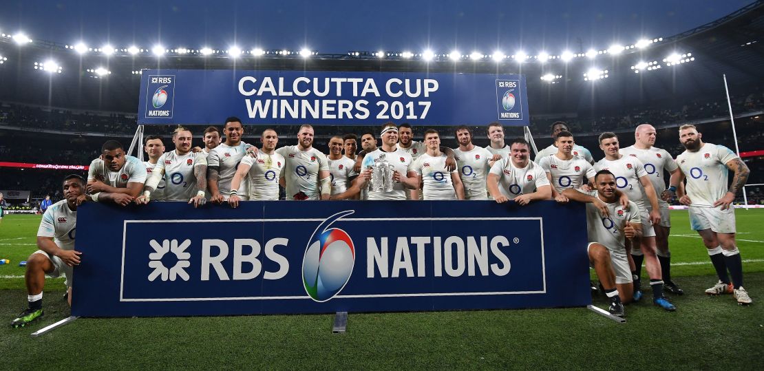 England's hooker and captain Dylan Hartley holds the Calcutta Cup trophy as he poses with teammates atfter winning the Six Nations