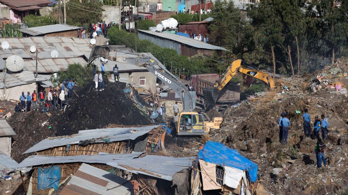 Excavators move mounds of trash Sunday as rescuers look for any possible survivors after the landslide.