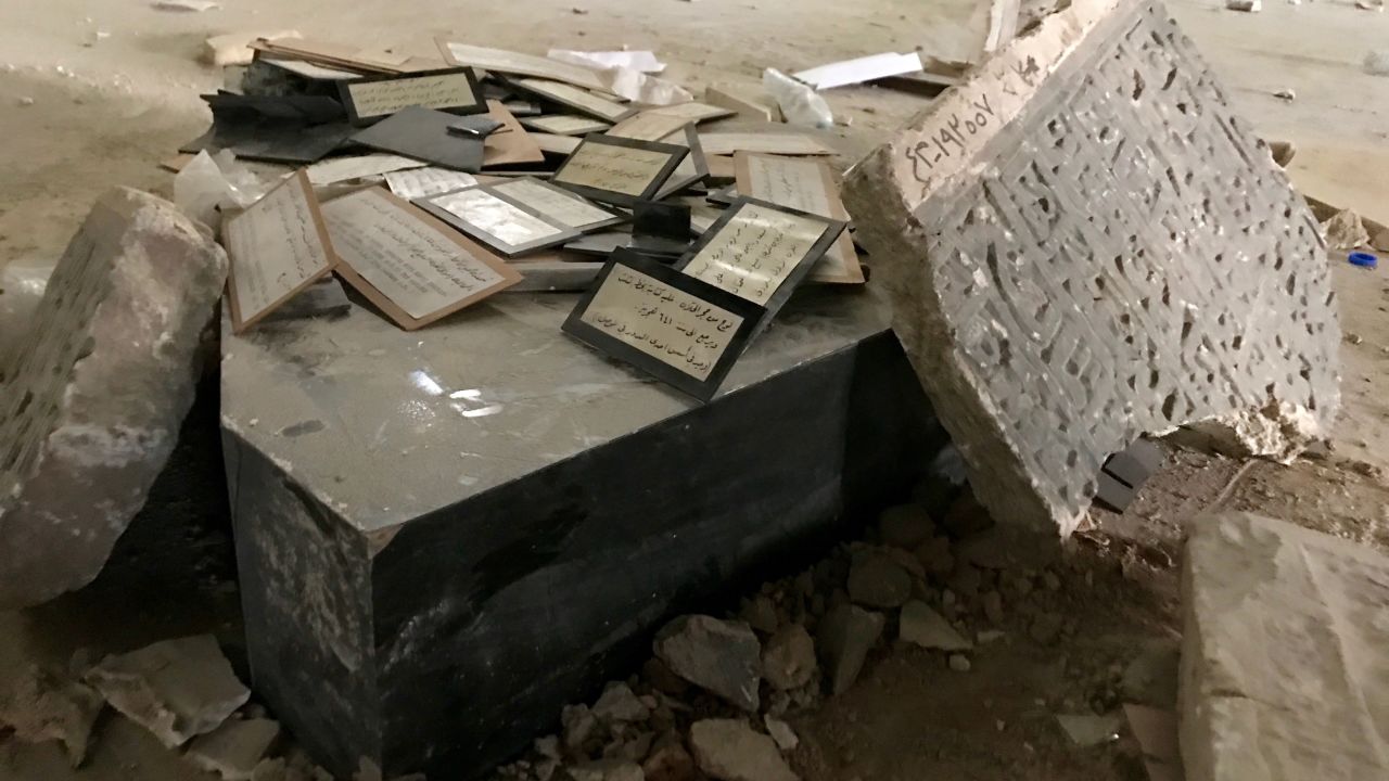 A stone with Islamic writing  stands next to a collection of display labels that were used in the curation of the museum.