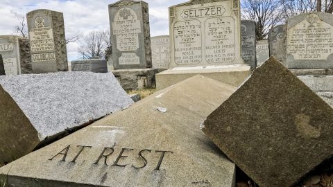 A headstone lies broken in two after vandalism at Mount Carmel Cemetery.
