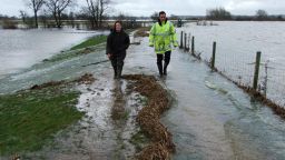 Shepherd walks with a colleague along the earth bund that should protect her village from flooding.