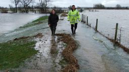 Shepherd walks with a colleague along the earth bund that should protect her village from flooding. 