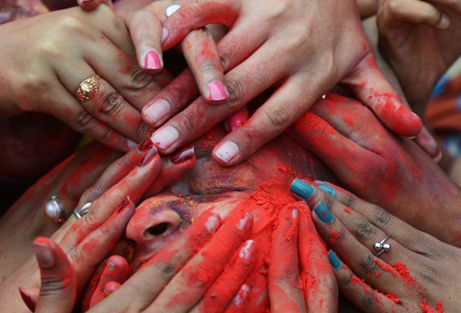 Students in Kolkata, India, smear colored powder at an event to celebrate Holi on Tuesday, March 7.