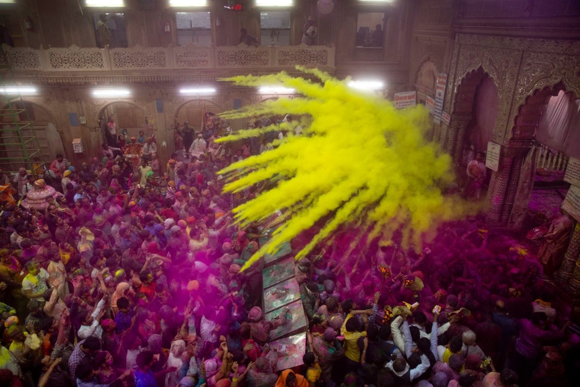 Hindu devotees throw colored powder on one another inside a temple in Vrindavan, India, on Wednesday, March 8. 