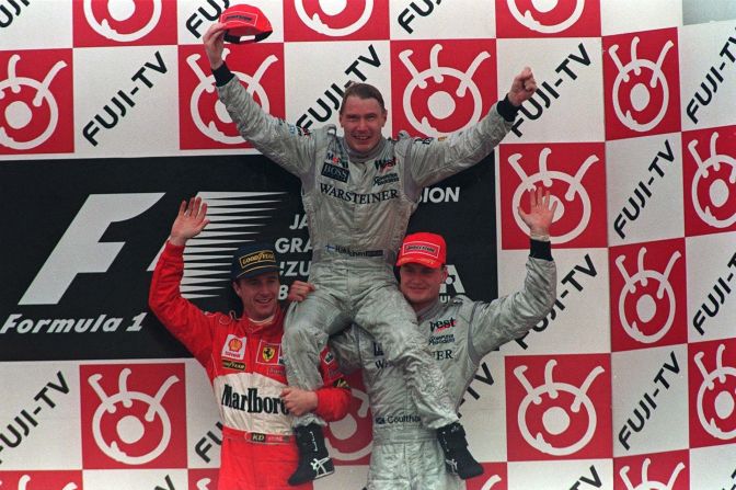 Hakkinen sits on the shoulders of Eddie Irvine (left) and his McLaren Mercedes teammate David Coulthard at the Suzuka race track in 1998 -- the year he won his first drivers title.