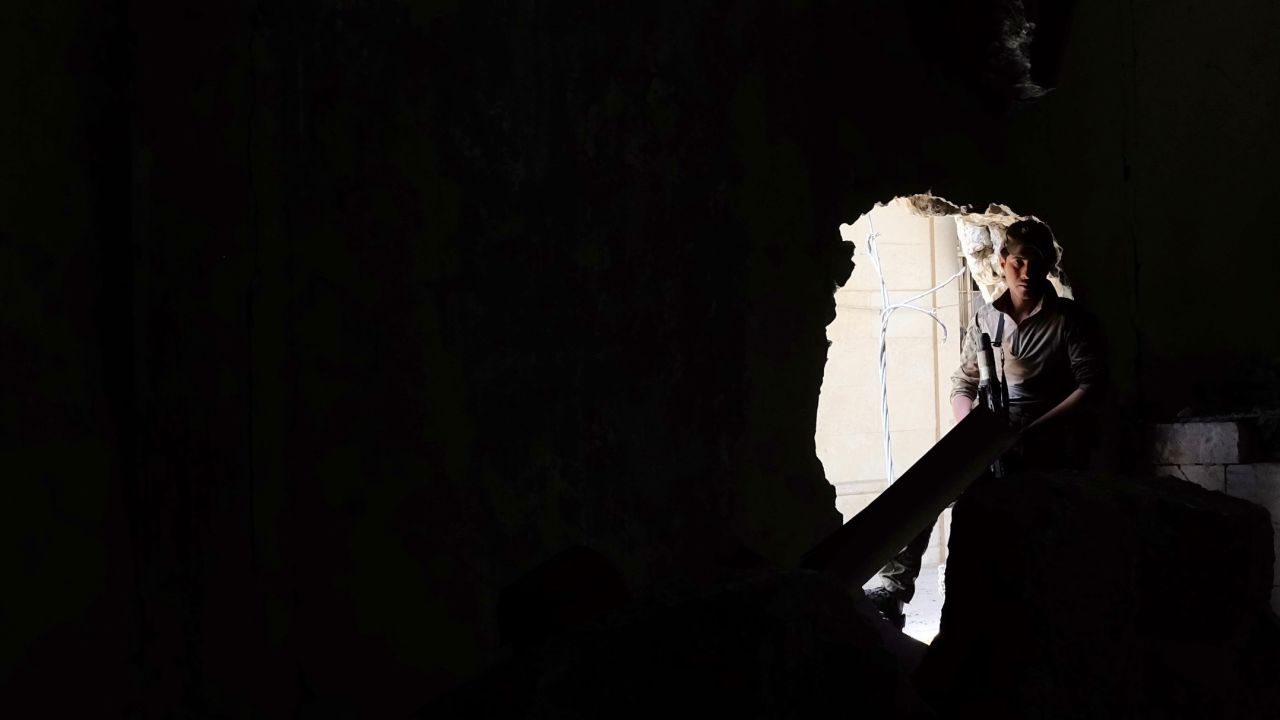 A soldier sits in the hole in the wall that is now the entrance to Mosul's museum.