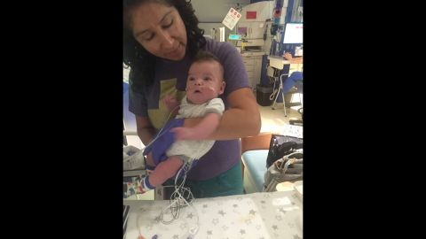 A physical therapist holds Beckham in the NICU.