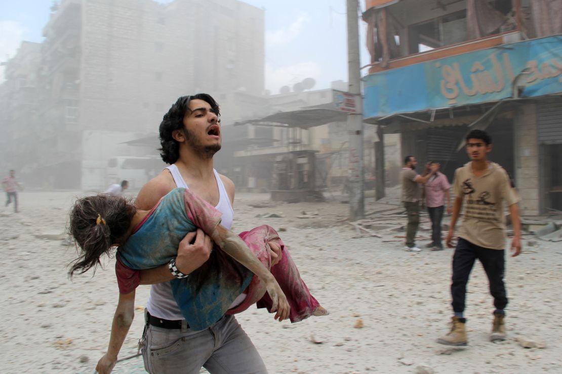 A man carries a young girl who was injured on June 3, 2014 in Kallaseh district in the northern city of Aleppo. 