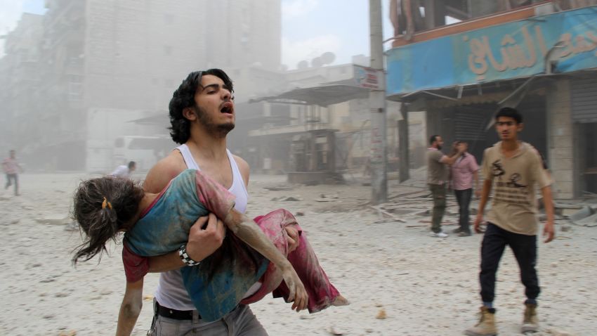 A man carries a young girl who was injured in a reported barrel-bomb attack by government forces on June 3, 2014 in Kallaseh district in the northern city of Aleppo. Some 2,000 civilians, including more than 500 children, have been killed in regime air strikes on rebel-held areas of Aleppo since January, many of them in barrel bomb attacks. AFP PHOTO / BARAA AL-HALABI        (Photo credit should read BARAA AL-HALABI/AFP/Getty Images)