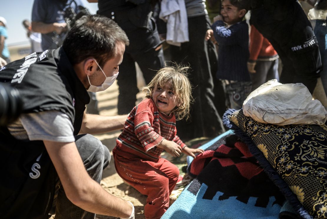 A Syrian Kurdish child cries as Turkish police search their bags after they crossed the border between Syria and Turkey at the southeastern town of Suruc in Sanliurfa province on September 23, 2014. 