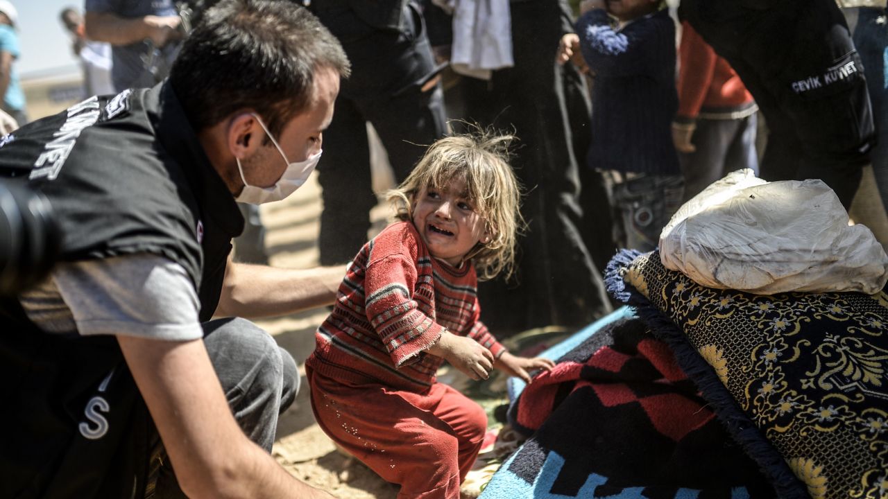 A Syrian Kurdish child cries as Turkish police search their bags after they crossed the border between Syria and Turkey at the southeastern town of Suruc in Sanliurfa province on September 23, 2014. The UN refugee agency warned Tuesday that as many as 400,000 people may flee to Turkey from Syria's Kurdish region to escape attacks by the Islamic State group.  AFP PHOTO / BULENT KILIC        (Photo credit should read BULENT KILIC/AFP/Getty Images)