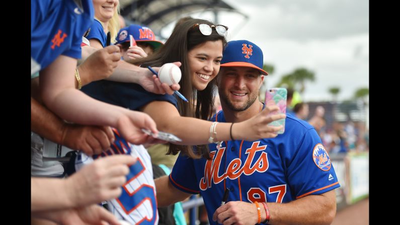 Former football star Tim Tebow, who is now a minor-league baseball player, poses with a fan before a spring-training game in Port St. Lucie, Florida, on Wednesday, March 8.