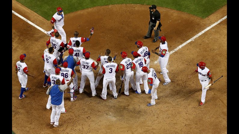Nelson Cruz is congratulated by his Dominican teammates after he hit a three-run home run against the United States on Saturday, March 11. Both teams advanced to the next round of the World Baseball Classic.<br />