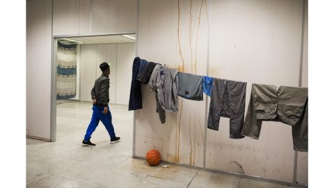 A refugee passes drying laundry at the group's Vluchttoren location in 2015. Many of the buildings squatted are given a name beginning with "vlucht" meaning "flight," a moniker for refugees in Dutch.