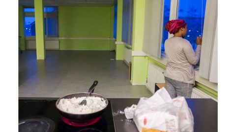A woman from We Are Here speaks on the phone while cooking at the women's building in Amsterdam west.