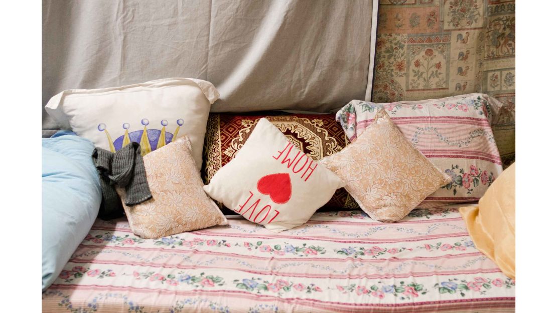 A bed is made with donated blankets and pillows in a women's room at a WAH location in Amsterdam west.