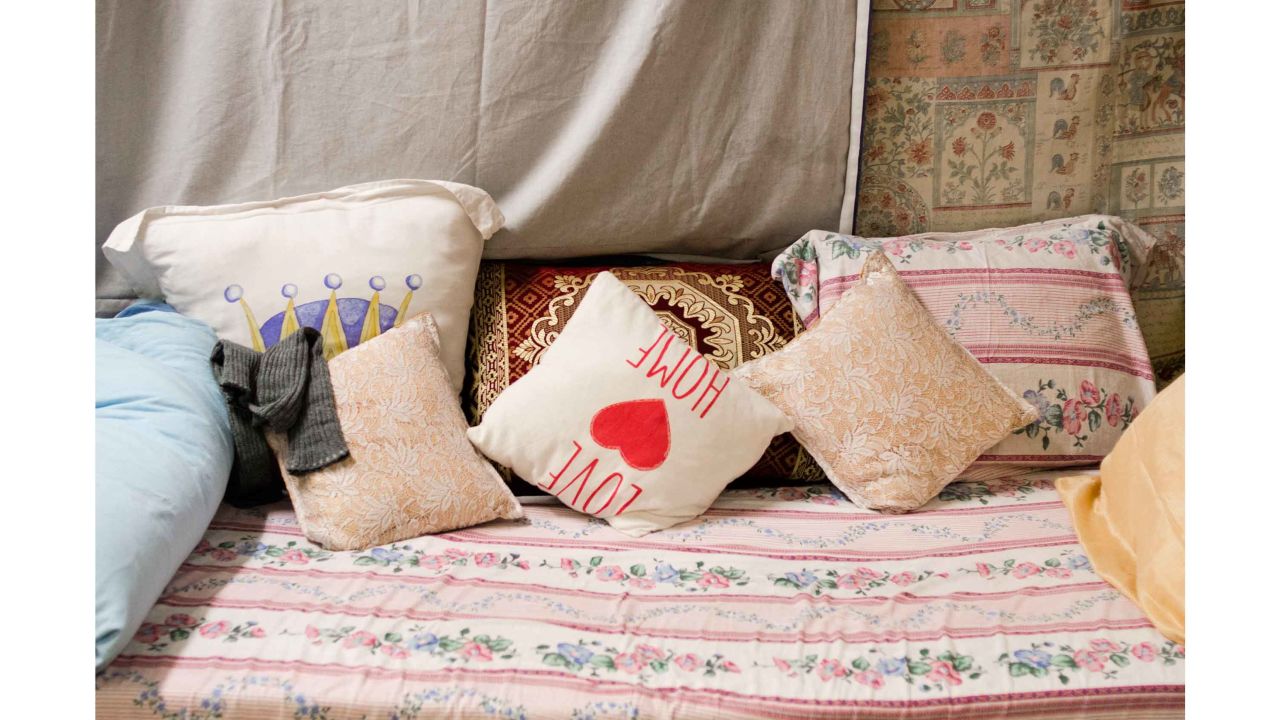 A bed is made with donated blankets and pillows in a women's room at a WAH location in Amsterdam west.