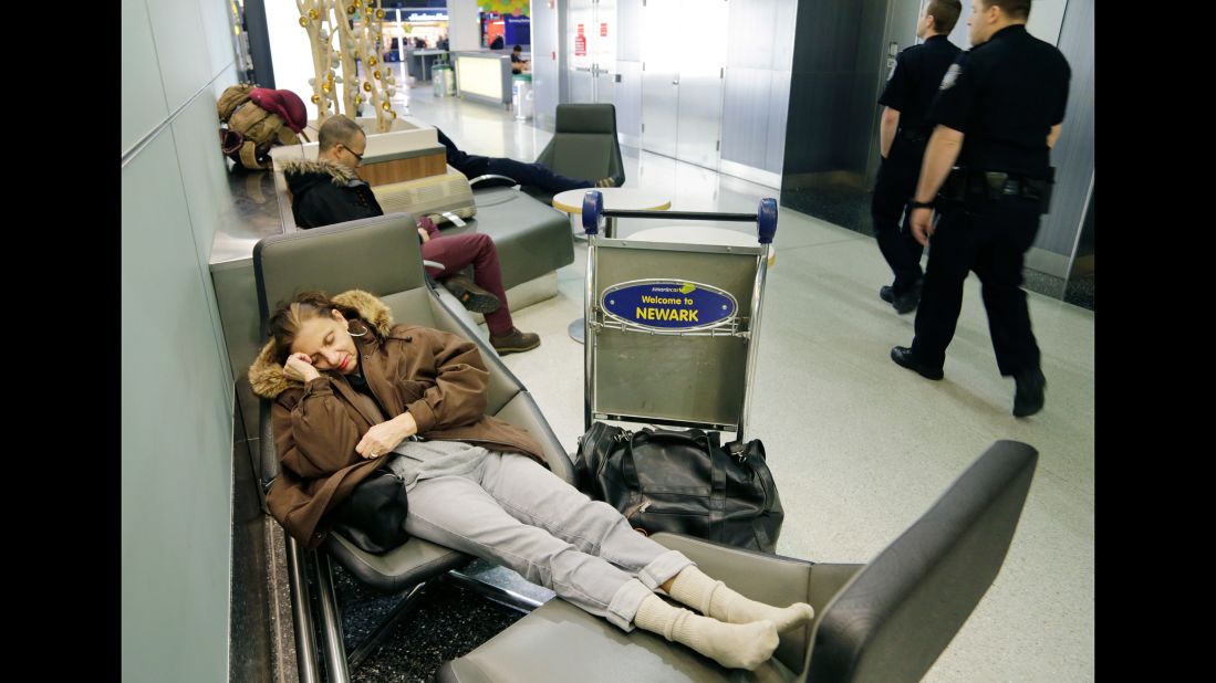 Yvonne Mouskourie makes herself comfortable after her morning flight to Florida was canceled in Newark, New Jersey.