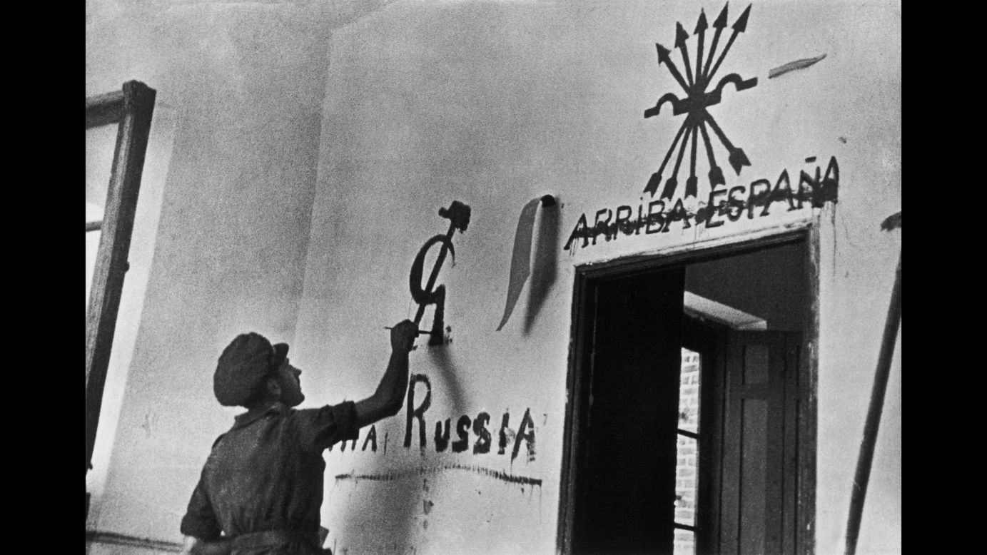 A Republican soldier draws a communist symbol after crossing out a pro-Franco slogan in Aragon.