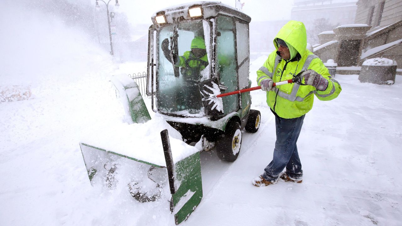 Jason Roy clears the windshield of a small plow being used to clear snow at City Hall in Worcester, Massachusetts, on March 14.