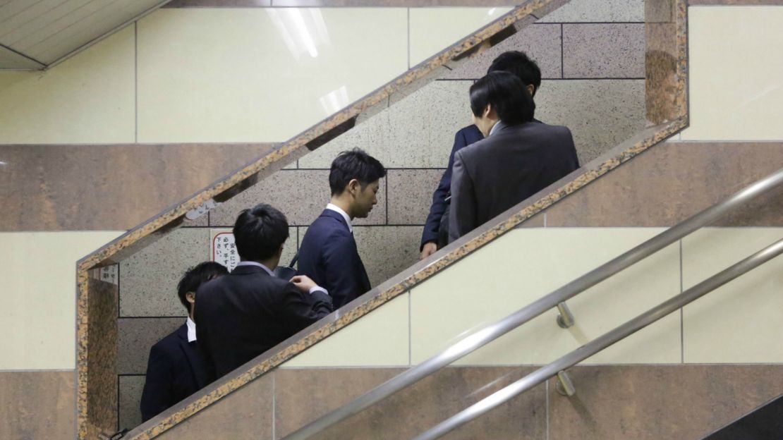 Going up? Salarymen on the fast track in Tokyo.