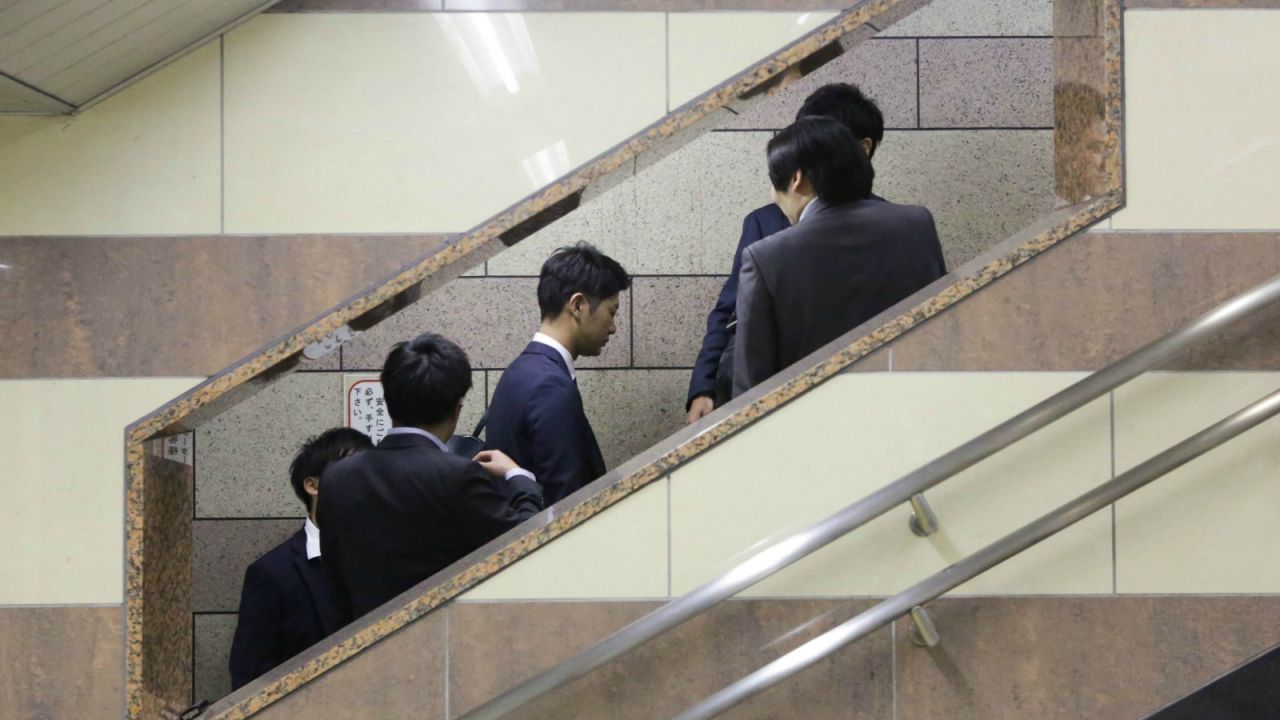 Going up? Salarymen on the fast track in Tokyo.